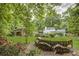 Spacious backyard features white brick home, red outbuilding, and pool surrounded by lush landscaping and greenery at 1615 Arden Sw Dr, Marietta, GA 30008