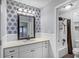 Bright bathroom features stylish wallpaper, a modern vanity, and neutral countertops at 1615 Arden Sw Dr, Marietta, GA 30008