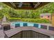 Enjoy pool views from the outdoor bar and dining area, set amongst lush trees and the charming red outbuilding at 1615 Arden Sw Dr, Marietta, GA 30008