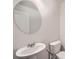 Bathroom featuring a modern sink, toilet, and round mirror for a sleek, minimalist design at 33 Oxford Ln, Kingston, GA 30145