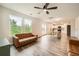 Open-concept living room with modern ceiling fan, wood-style flooring, and bright windows at 33 Oxford Ln, Kingston, GA 30145