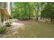 Spacious backyard featuring a lush lawn, mature trees, and a patio area for outdoor enjoyment at 3335 New Heritage Dr, Alpharetta, GA 30022