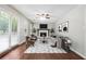 Bright living room features a stone fireplace, ceiling fan, hardwood floors, and modern neutral-toned furniture at 3335 New Heritage Dr, Alpharetta, GA 30022