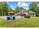Lush backyard showcasing an in-ground pool, a patio with lounge chairs and dining area, all surrounded by mature trees at 9950 Farmbrook Ln, Johns Creek, GA 30022