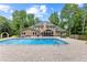 Expansive backyard with a large in-ground pool, brick patio, lounge chairs, and lush landscaping creating a private oasis at 9950 Farmbrook Ln, Johns Creek, GA 30022
