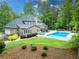 Private backyard oasis with a sparkling pool, lush greenery, and outdoor lounge seating, perfect for relaxation at 9950 Farmbrook Ln, Johns Creek, GA 30022
