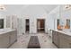 Bright bathroom with double sink, vanity, walk-in shower, and a gray upholstered bench at 9950 Farmbrook Ln, Johns Creek, GA 30022
