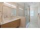 Modern bathroom featuring glass-enclosed shower, wood vanity, and modern lighting at 9950 Farmbrook Ln, Johns Creek, GA 30022