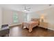 Bright bedroom features hardwood floors, soft natural light, ceiling fan and stylish furnishings at 9950 Farmbrook Ln, Johns Creek, GA 30022