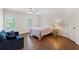 Bright bedroom features hardwood floors, soft natural light, and stylish furnishings at 9950 Farmbrook Ln, Johns Creek, GA 30022