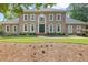 Elegant two-story home featuring a neutral facade, complemented by symmetrical windows and lush landscaping at 9950 Farmbrook Ln, Johns Creek, GA 30022