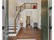 Bright and inviting foyer featuring hardwood floors, a modern staircase, and an open layout at 9950 Farmbrook Ln, Johns Creek, GA 30022