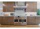 Close up on a stainless steel range with custom cabinetry at 9950 Farmbrook Ln, Johns Creek, GA 30022