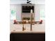 Modern kitchen featuring dual faucets, quartz countertops, and an open layout with dining area in the background at 9950 Farmbrook Ln, Johns Creek, GA 30022