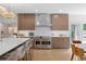 Gourmet kitchen with custom cabinetry, high-end appliances, and a breakfast bar overlooking the dining area at 9950 Farmbrook Ln, Johns Creek, GA 30022