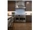 Spacious kitchen with stainless steel range, custom cabinets, and hardwood floors, creating an inviting culinary space at 9950 Farmbrook Ln, Johns Creek, GA 30022