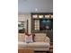 Cozy living room features a stylish wet bar with glass cabinets and a comfortable leather couch at 9950 Farmbrook Ln, Johns Creek, GA 30022