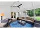 Covered outdoor patio with modern seating, ceiling fan, and landscaped backyard view at 9950 Farmbrook Ln, Johns Creek, GA 30022