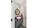 Elegant powder room featuring a vessel sink, dark granite countertop, round mirror and gray tiled floor at 9950 Farmbrook Ln, Johns Creek, GA 30022