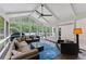 Inviting screened-in porch with comfortable seating, a ceiling fan, and views of the serene backyard and pool at 9950 Farmbrook Ln, Johns Creek, GA 30022