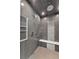 Modern walk-in shower with gray tile and built in niche and bench at 9950 Farmbrook Ln, Johns Creek, GA 30022