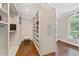 Spacious walk-in closet with custom shelving, drawers and natural lighting at 9950 Farmbrook Ln, Johns Creek, GA 30022