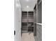 Walk-in closet with gray built-in shelving and drawers, and safe at 9950 Farmbrook Ln, Johns Creek, GA 30022