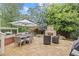 Stone patio in backyard features a stone fireplace, dining table and white umbrella at 11660 Crabapple Rd, Roswell, GA 30075