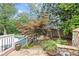 A backyard stone path leads to a view of the pool, greenery, and manicured landscaping at 11660 Crabapple Rd, Roswell, GA 30075