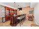 Entertainer's basement bar with seating, custom cabinetry, and brick accents at 11660 Crabapple Rd, Roswell, GA 30075