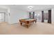 Spacious basement rec room with pool table, neutral carpeting, and white walls at 11660 Crabapple Rd, Roswell, GA 30075