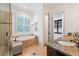 Elegant bathroom with a soaking tub, glass-enclosed shower, and granite countertops leading to the walk-in closet at 11660 Crabapple Rd, Roswell, GA 30075