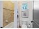 Cozy bathroom with tiled walls, shower-tub combo, and decorative window at 11660 Crabapple Rd, Roswell, GA 30075