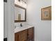 Charming bathroom featuring a wood vanity, framed mirror, and modern lighting at 11660 Crabapple Rd, Roswell, GA 30075