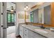 Bright bathroom boasts double vanities with granite countertop and decorative lighting at 11660 Crabapple Rd, Roswell, GA 30075