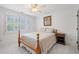Neutral bedroom with a wood frame bed, ceiling fan, white shutters, and a side table at 11660 Crabapple Rd, Roswell, GA 30075