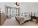 Bright bedroom with neutral tones, ceiling fan, and large windows with plantation shutters for natural light at 11660 Crabapple Rd, Roswell, GA 30075
