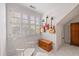 Well-lit bedroom with three guitars on wall, rocking chair, chest, and white shutters on window at 11660 Crabapple Rd, Roswell, GA 30075