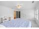Spacious bedroom featuring a bed with blue bedding, built-in desk, ceiling fan, and white walls at 11660 Crabapple Rd, Roswell, GA 30075