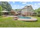 Rear exterior view showcases a stunning pool, patio, and well-maintained lawn at 11660 Crabapple Rd, Roswell, GA 30075