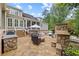 Exterior view from the backyard features a stone fireplace, patio and dining area at 11660 Crabapple Rd, Roswell, GA 30075