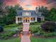 Charming home features lush landscaping, a brick walkway, and a welcoming covered porch at 11660 Crabapple Rd, Roswell, GA 30075