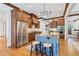 Bright kitchen features wood cabinets, stainless steel appliances, and a granite island with seating at 11660 Crabapple Rd, Roswell, GA 30075
