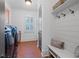 Laundry room featuring brick floors, bench, and modern washer and dryer at 11660 Crabapple Rd, Roswell, GA 30075