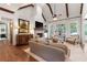 Inviting living room with vaulted ceilings, exposed beams, and a cozy brick fireplace at 11660 Crabapple Rd, Roswell, GA 30075