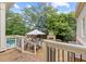 Back deck patio with wood railing and a view of the lush backyard and swimming pool at 11660 Crabapple Rd, Roswell, GA 30075