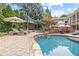 Backyard pool with tanning chairs, an in-ground hot tub, patio, and manicured landscaping at 11660 Crabapple Rd, Roswell, GA 30075