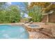 Beautiful backyard pool and patio area with a stone hot tub perfect for relaxing and entertaining at 11660 Crabapple Rd, Roswell, GA 30075
