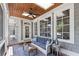 Covered porch with wood ceiling, comfortable seating and stylish decor at 11660 Crabapple Rd, Roswell, GA 30075