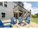 A backyard with a stone patio, fire pit, blue Adirondack chairs, and multilevel deck at 155 Marlow Dr, Woodstock, GA 30188